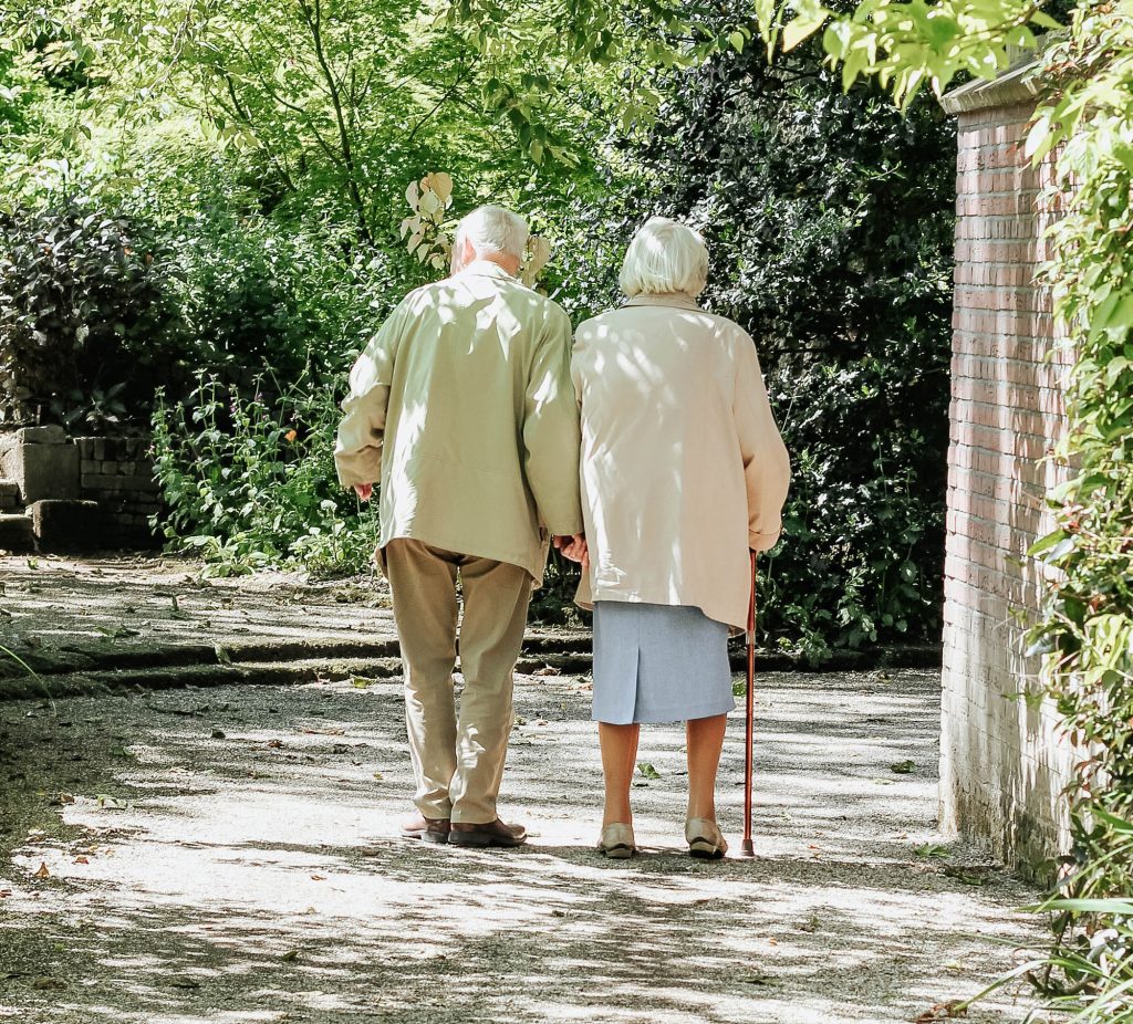 two seniors walk in the park