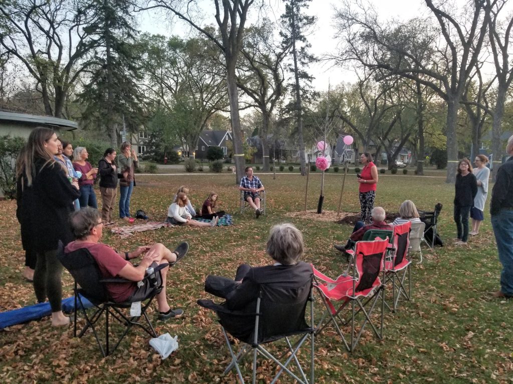 neighbourhood gathering around the commemorative tree to honour Babe and Jean